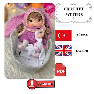 Peut inclure: Une poupée au crochet avec un chapeau et une robe de lapin, assise dans un panier gris avec un jouet lapin blanc. La poupée a des cheveux bruns et porte une robe violette. L'image comprend le texte "CROCHET PATTERN" et "DOWNLOAD".