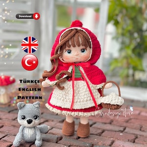 Op de afbeelding: Haakpatroon voor een rood gekapte meisjespop en een grijze wolf. Het patroon is beschikbaar in zowel Engels als Turks. De pop houdt een mandje vast.
