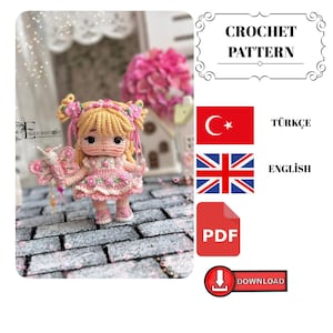Könnte beinhalten: Eine Häkelpuppe mit blondem Haar, die ein rosa Kleid mit kleinen Blumen und ein passendes Stirnband trägt. Die Puppe hält einen rosa Schmetterlingsstab. Der Text auf dem Bild umfasst CROCHET PATTERN, TÜRKÇE, ENGLISH, PDF und DOWNLOAD.
