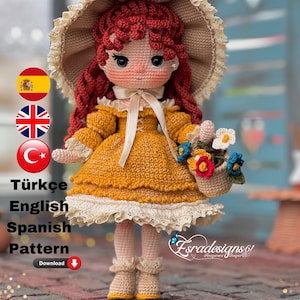 May include: Crocheted doll with red hair wearing a yellow dress and a brown hat. The doll is holding a basket of flowers. The doll is standing on a brick surface. The text "Esradesigns61" is visible in the image.