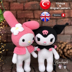 May include: Two crocheted amigurumi dolls, one pink and one black, with white accents. The pink doll has a flower on its head and a pink cape. The black doll has a skull on its head and a black cape. The dolls are standing on a brick surface. Türkçe & English pattern Download