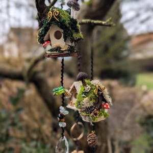 Puede incluir: Casas para pájaros colgantes decorativas con acentos de musgo, hongos y piedras preciosas. Las casas en miniatura están suspendidas de una rama de árbol. Una adición encantadora a cualquier jardín o espacio al aire libre.