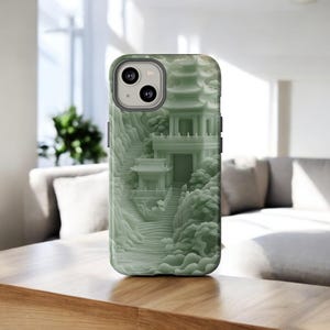May include: A green phone case with a 3D design of a pagoda and surrounding landscape. The case has a raised design and a matte finish.