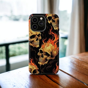 May include: A black phone case with a skull and flames design. The case has a camera lens cutout and a black background.