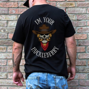 May include: Black t-shirt with a skull wearing a cowboy hat and a red bandana. The text "I'm Your Huckleberry" is printed on the shirt.