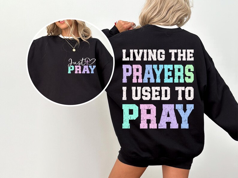 May include: Black sweatshirt with the text "Living the prayers I used to pray" in rainbow colors on the back and "Just Pray" with a heart on the front.