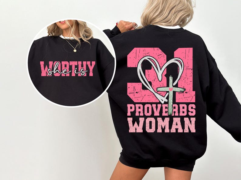 May include: Black sweatshirt with pink text on the front that says "she is WORTHY" and pink text on the back that says "PROVERBS WOMAN" with a pink heart and cross graphic.