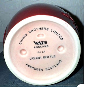 K&ouml;nnte beinhalten: Eine weinrote Lik&ouml;rflasche mit wei&szlig;em Boden. Der Boden tr&auml;gt die Aufschrift "CHIVAS BROTHERS LIMITED", "WADE ENGLAND", "LIQUOR BOTTLE" und "ABERDEEN SCOTLAND".