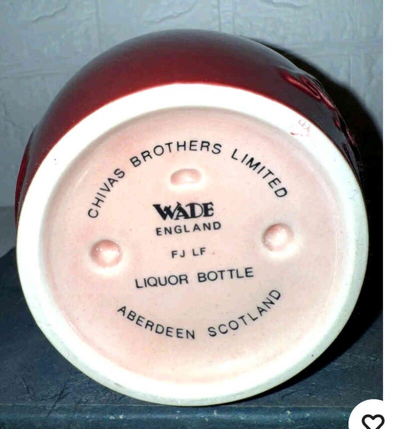 K&ouml;nnte beinhalten: Eine weinrote Lik&ouml;rflasche mit wei&szlig;em Boden. Der Boden tr&auml;gt die Aufschrift "CHIVAS BROTHERS LIMITED", "WADE ENGLAND", "LIQUOR BOTTLE" und "ABERDEEN SCOTLAND".