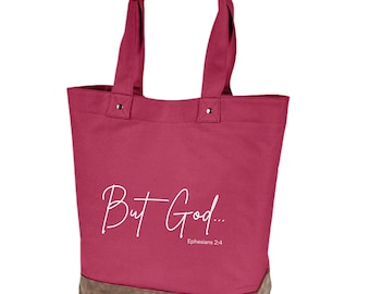 May include: A pink canvas tote bag with brown leather handles and trim. The bag has the text "But God... Ephesians 2:4" printed in white.