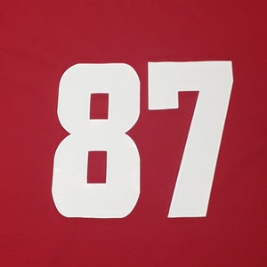 May include: White numbers 87 on a red background.
