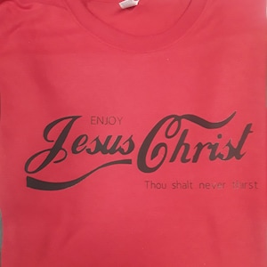 May include: Red t-shirt with black text that reads "Enjoy Jesus Christ Thou shalt never thirst".