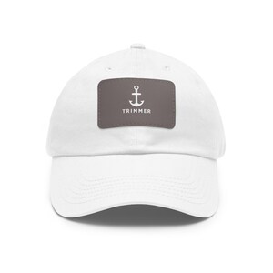 May include: White baseball cap with a brown patch featuring a white anchor and the text "TRIMMER".