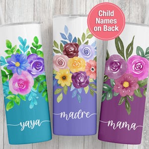 May include: Three floral-themed tumblers with white tops and colorful watercolor designs. One is teal with "yaya" written on it, another is purple with "madre", and the last is dark purple with "mama". The tumblers have a straw.