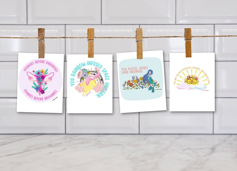 Op de afbeelding: Vier ge&iuml;llustreerde kaarten met een roze baarmoeder met bloemen, een geel eenhoorn met een regenboog, een blauwe zeemeermin met bloemen en een gele zon met een wolk. De kaarten hebben tekst die luidt "Uteruses before Duderuses, Ovaries before Brovaries", "You rainbow-infused space unicorn", "You poetic, noble land mermaid", en "You are the most beautiful, shining, sun-kissed soul".