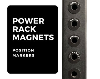 Puede incluir: Imanes negros para rack de potencia con texto blanco que dice "POWER RACK MAGNETS" y "POSITION MARKERS". Los imanes están diseñados para fijarse a un rack de pesas y tienen etiquetas para diferentes ejercicios, incluyendo "SQUAT", "BENCH", "INCLINE", "HIP THRUST".
