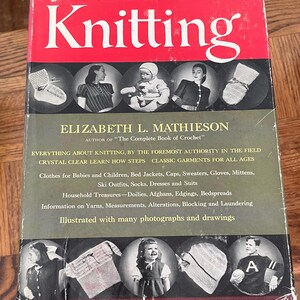 May include: A vintage book titled "The Complete Book of Knitting" by Elizabeth L. Mathieson, author of "The Complete Book of Crochet". The book cover features a red background with the title in white lettering. The cover also includes several illustrations of knitted items, including hats, mittens, and sweaters.