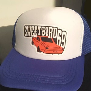 May include: White and blue trucker hat with a red and black graphic of a car and the text "Sweetbird 69".