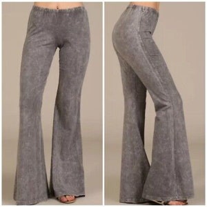May include: Gray wide-leg pants with a slightly flared hem. The pants have a distressed, acid-washed look.