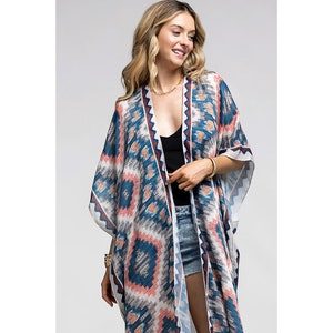 May include: A long, white, blue, and pink patterned kimono with a geometric design. The kimono has a V-neck and short sleeves.