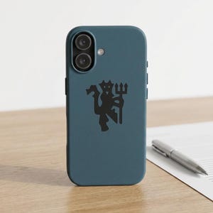 May include: A matte slate blue smartphone case featuring a black graphic of a stylized devil figure holding a trident. The case has a dual-lens camera cutout at the top left and a small circular flash opening next to the camera module.