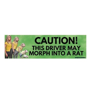 Puede incluir: Una pegatina rectangular verde con el texto "CAUTION! THIS DRIVER MAY MORPH INTO A RAT" en negro. La pegatina también presenta una ilustración de una persona transformándose en una rata.