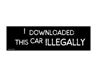 May include: Black rectangular sticker with white text that reads "I DOWNLOADED THIS CAR ILLEGALLY". The sticker is designed to be applied to a vehicle.