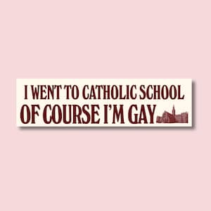 Op de afbeelding: Een rechthoekige sticker met de tekst "I WENT TO CATHOLIC SCHOOL OF COURSE I'M GAY" in kastanjebruine letters. Een kleine illustratie van een kerk staat rechts. De sticker heeft een crème achtergrond.
