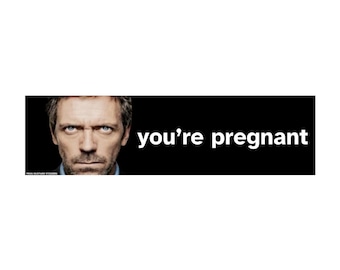 May include: A rectangular sticker featuring a close-up portrait of a man with short brown hair and blue eyes on the left side, set against a black background. To the right of the portrait, the white text reads you're pregnant in lowercase letters.