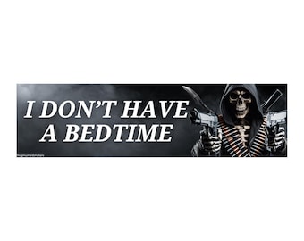 May include: Black bumper sticker with the text "I DON'T HAVE A BEDTIME" in white. The image features a grim reaper holding two guns. The background is dark and smoky.