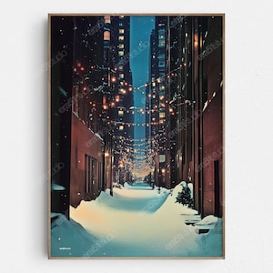 May include: A framed art print depicts a snow-covered alleyway between tall buildings at night. Strings of lights illuminate the scene, creating a warm glow against the cool blues and browns of the buildings and snow.