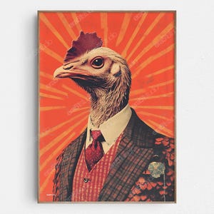May include: A framed art print featuring a chicken with a human-like appearance, wearing a suit and tie. The artwork has a vintage style with a red and orange color scheme. The chicken is the focal point, set against a radial burst background.