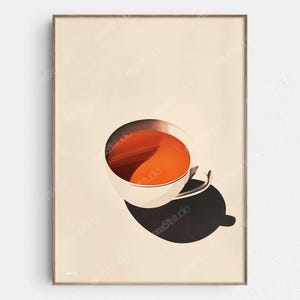 May include: A framed art print featuring a stylized image of a cup of tea. The cup is white with a silver handle, filled with orange liquid. A dark shadow is cast below the cup, and the background is a light beige color.