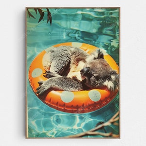 Puede incluir: Un koala lleva un flotador inflable de color naranja brillante con lunares blancos y flota en una piscina azul turquesa. El koala está durmiendo con la cabeza apoyada en el flotador.