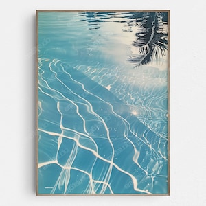 May include: Abstract art print featuring a close-up of rippling water with a palm tree reflection. The water is a light blue color with white lines and a light blue background.