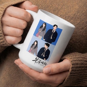 May include: A white ceramic mug featuring a graphic illustration of two people in two separate blue-toned panels. Below the illustrations, black Chinese characters and the English text "The only spring" are printed on the mug surface.