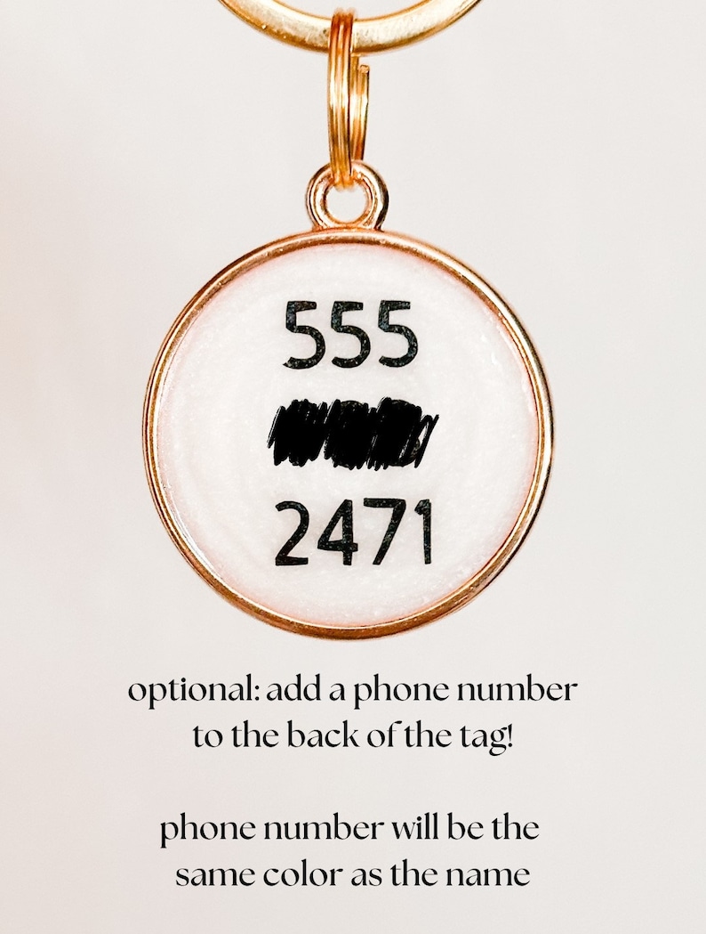 May include: Gold key chain with a round tag. The tag has a white background with black numbers 555 and 2471. The text "optional: add a phone number to the back of the tag!" is below the tag. The text "phone number will be the same color as the name" is below the first text.