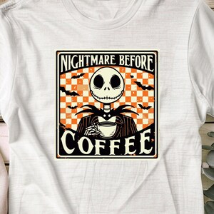 Pode incluir: Uma camiseta branca com um gr&aacute;fico de estilo vintage que apresenta Jack Skellington de "O Estranho Mundo de Jack" segurando uma x&iacute;cara de caf&eacute;. O gr&aacute;fico tem um fundo xadrez com morcegos voando ao redor. O texto diz "Nightmare Before Coffee".