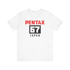 May include: White t-shirt with a red "PENTAX 67 JAPAN" logo printed on the front.