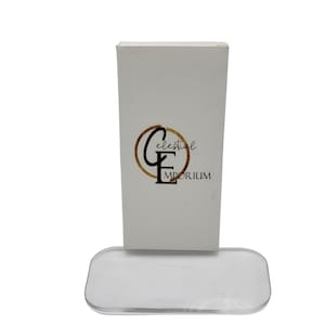 May include: White box with a gold circle and the text "Celestial Emporium" in black. The box is sitting on a clear acrylic base.