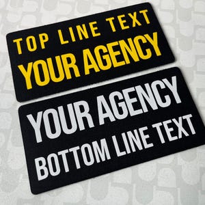 Puede incluir: Dos parches rectangulares negros con texto blanco y amarillo. El parche superior dice "TOP LINE TEXT" y "YOUR AGENCY" en amarillo. El parche inferior dice "YOUR AGENCY" y "BOTTOM LINE TEXT" en blanco.