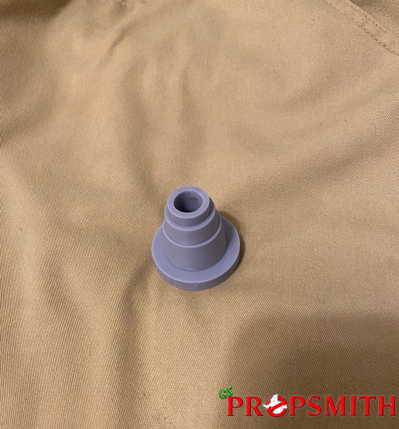 May include: A gray plastic cone-shaped object with a circular base. The object has four layers, each with a slightly smaller diameter than the one below it.