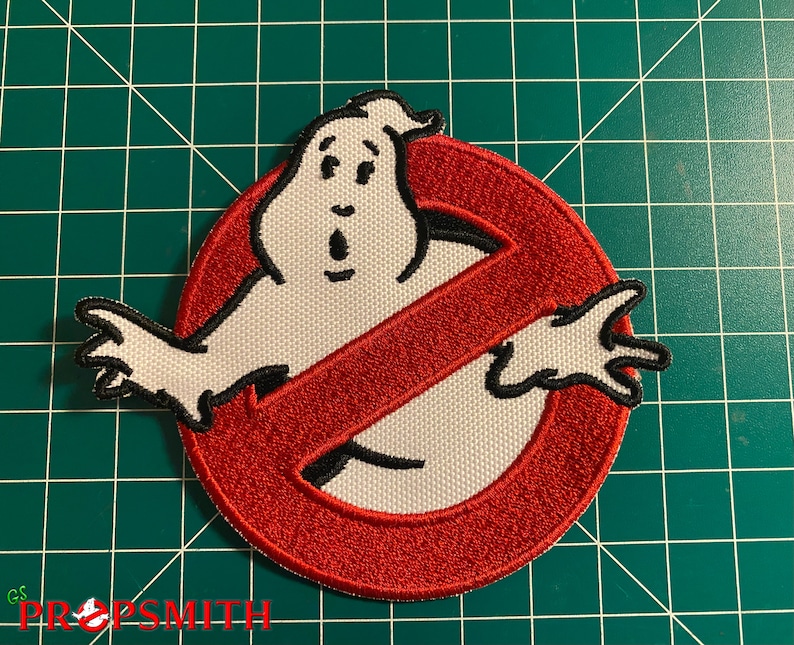 Pu&ograve; includere: Toppa ricamata rossa e bianca con un fantasma in un simbolo di divieto. Il fantasma &egrave; bianco con occhi neri e una bocca. Il simbolo di divieto &egrave; rosso con un contorno nero.