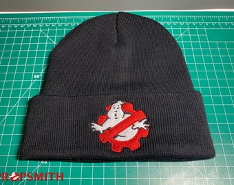 Op de afbeelding: Zwarte beanie met een geborduurd Ghostbusters-logo in rood en wit. Het logo toont een geest met een verbodsteken erboven.