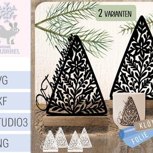 Puede incluir: Decoraciones de árbol de Navidad negras cortadas con láser con intrincados diseños florales. La imagen muestra dos adornos en forma de árbol, uno sobre una base de madera y una versión más pequeña en una taza. El texto "2 VARIANTEN" es visible.