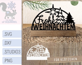 Könnte beinhalten: Schwarze lasergeschnittene Weihnachtsdekoration aus Holz mit dem deutschen Schriftzug "Frohe Weihnachten". Das Design umfasst einen Stern und stilisierte Weihnachtsbäume, montiert auf einem Holzsockel.