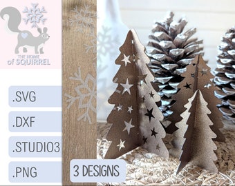 May include: Three metallic gold Christmas tree cutouts with star designs. The trees are standing on a woven wicker surface with two pine cones in the background.