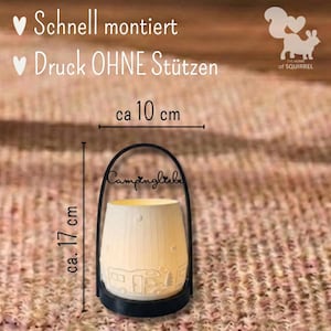 Op de afbeelding: Een witte keramische lantaarn met een zwarte handgreep, met een camperontwerp en het woord "Campingliebe". De lantaarn is ongeveer 17 cm hoog en 10 cm breed. De tekst "Schnell montiert" en "Druck OHNE St&uuml;tzen" is ook zichtbaar.