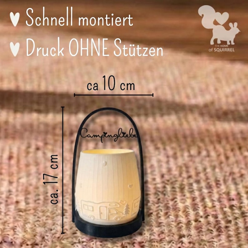 Op de afbeelding: Een witte keramische lantaarn met een zwarte handgreep, met een camperontwerp en het woord "Campingliebe". De lantaarn is ongeveer 17 cm hoog en 10 cm breed. De tekst "Schnell montiert" en "Druck OHNE St&uuml;tzen" is ook zichtbaar.