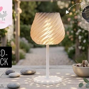 Op de afbeelding: Een crèmekleurige lamp met spiraalvormige textuur, witte voet en steel, van binnenuit verlicht. Een zonnepaneel is boven de lamp afgebeeld. De afbeelding bevat ook een kom met gedroogde zaaddozen en een paar gladde stenen.